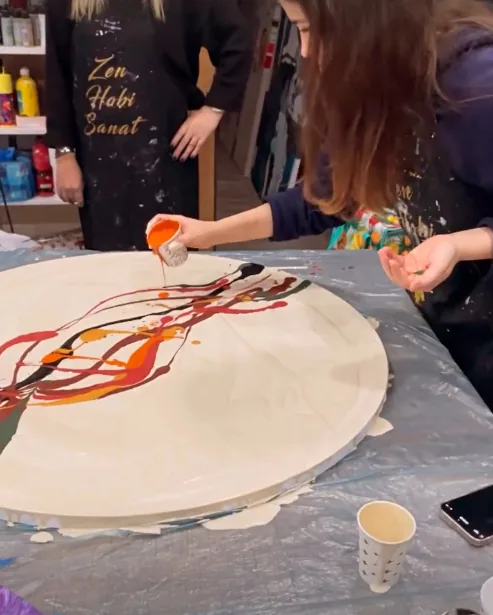 Atölyede pouring art tekniğiyle boya dökme anı